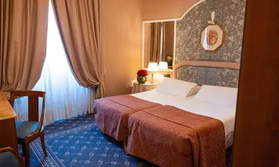 a hotel room with a bed and a window at Hotel Mecenate Palace in Rome