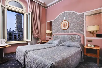 a bedroom with a bed and a large window at Hotel Mecenate Palace in Rome