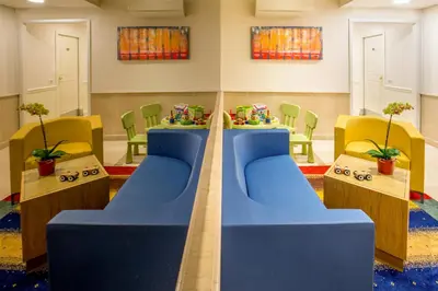 a waiting room with yellow chairs and a tv at Best Western Hotel Globus in Rome