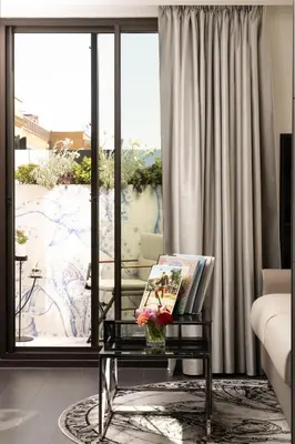 a living room with a table and a large window at art'otel Rome Piazza Sallustio in Rome