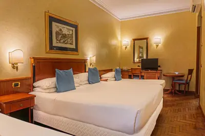 a hotel room with a large white bed with blue pillows at Hotel Miami in Rome
