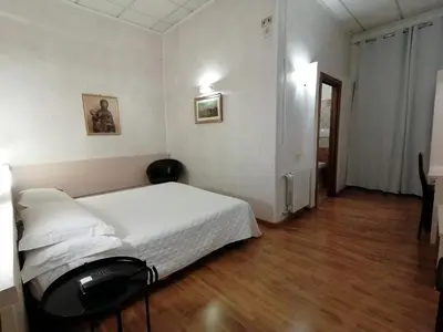 a bedroom with a white bed and a wooden floor at Hotel Julia Trevi - Spagna in Rome