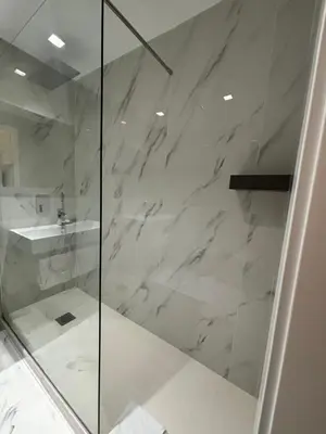 a shower with a glass door next to a sink at Hotel Gabriella in Rome