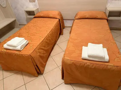 two beds with orange sheets in a room at Casa Zavatti in Rome