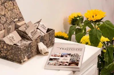 a book sitting on a table with flowers at B&B Arco Del Lauro in Rome