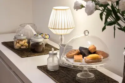 a table with a plate of cookies and a lamp at B&B Arco Del Lauro in Rome