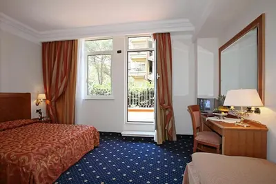 a hotel room with a bed and a desk and a window at Pinewood Hotel Rome in Rome