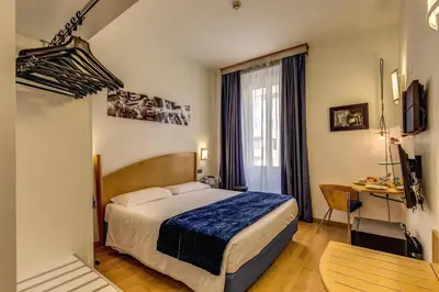 a hotel room with a bed and a desk at Hotel Franklin Feel The Sound in Rome