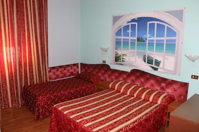 a hotel room with two beds and a window at Hotel Gabriele in Rome