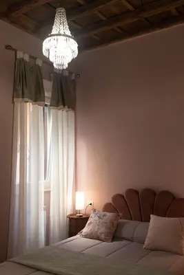 a bedroom with a bed with a chandelier and a window at Boutique Grifone in Rome