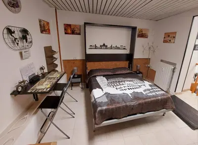a bedroom with a bed and a desk in it at Mini Suite Indipendente in Rome