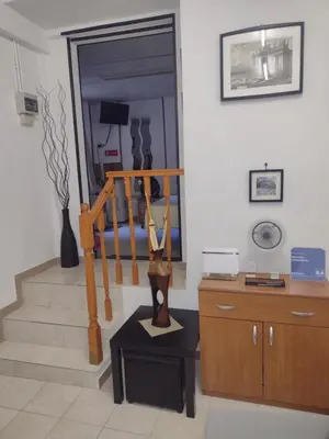 a living room with a stairway with a statue on a table at Mini Suite Indipendente in Rome