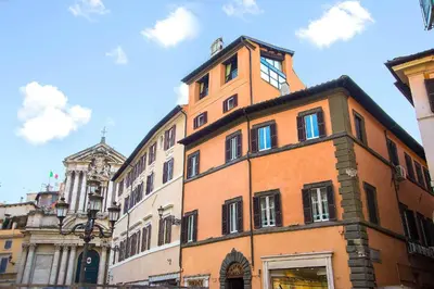 a tall orange building with a clock tower on top at Hotel Fontana in Rome