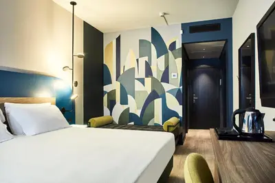 a bedroom with a white bed and a blue wall at Belstay Roma Aurelia in Rome