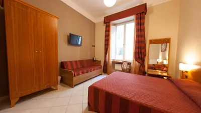 a bedroom with a bed and a couch and a window at Dama Private Rooms in Rome