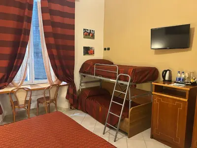 a room with a bunk bed and a desk and a television at Dama Private Rooms in Rome
