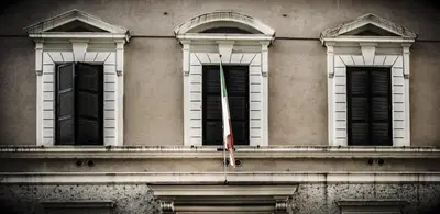a building with four windows and a flag on it at Dama Private Rooms in Rome