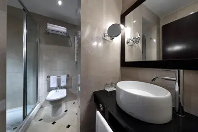 a bathroom with a sink and a shower and a mirror at Exe International Palace in Rome