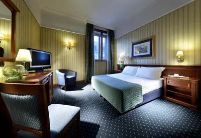 a hotel room with a bed and a television at Exe International Palace in Rome