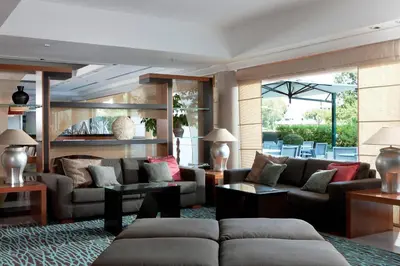 a living room with couches and tables and chairs at Courtyard by Marriott Rome Central Park in Rome