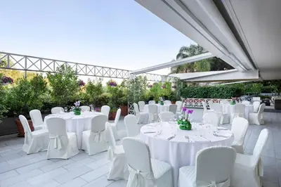 a marquee with white tables and white chairs at Courtyard by Marriott Rome Central Park in Rome