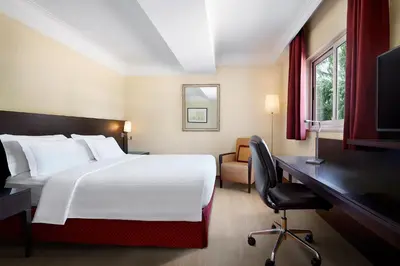 a hotel room with a large bed and a desk at Courtyard by Marriott Rome Central Park in Rome