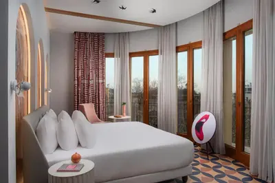 a bedroom with a large white bed and windows at nhow Roma in Rome
