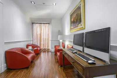 a living room with a desk with a computer on it at Gambrinus Hotel in Rome