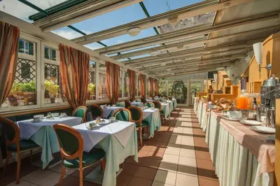 a restaurant with tables and chairs and a glass ceiling at Hotel Borromeo in Rome