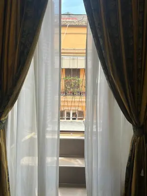 a view of a window with white curtains at Hotel Garda in Rome
