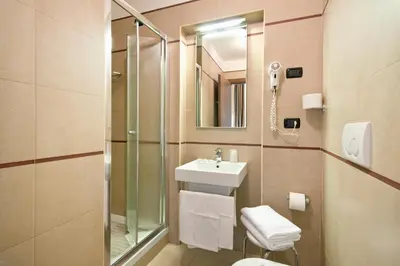 a bathroom with a sink and a toilet and a mirror at Hotel Marco Polo Rome in Rome