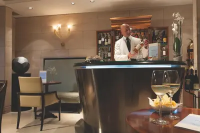a man is standing behind a bar in a restaurant at Stendhal Hotel in Rome