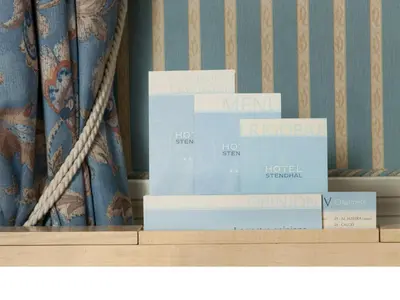 two stacks of books on a shelf with a curtain at Stendhal Hotel in Rome