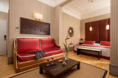 a living room with a red couch and a bed at Hotel Morgana in Rome
