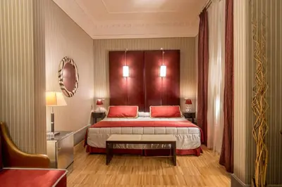 a bedroom with a large bed with red pillows at Hotel Morgana in Rome