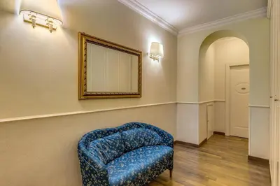 a blue chair in a room with a mirror at Hotel Anfiteatro Flavio in Rome