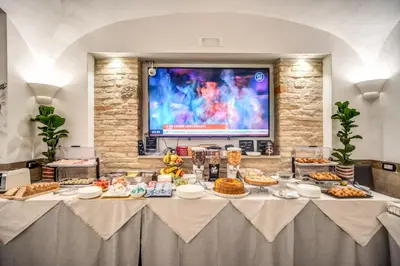 a table with food on it in a room with a tv at Hotel Centro Cavour Roma in Rome