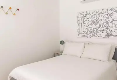 a bedroom with a white bed with a drawing on the wall at Palazzo Velli Suites in Rome
