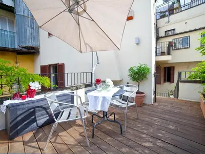 a patio with a table and chairs and an umbrella at Nostromondo Ciancaleoni Palace in Rome