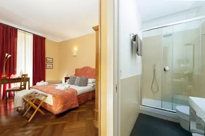 a bedroom with a bed and a bathroom with a shower at All'Orologio in Rome