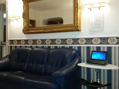 a black leather couch and a table with a laptop on it at Hotel Teti in Rome
