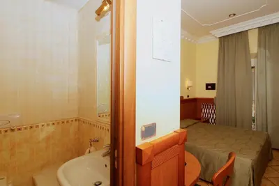 a bathroom with a bed and a tub and a sink at Hotel Meridiana in Rome