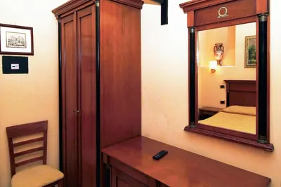 a bathroom with a mirror and a wooden cabinet at Hotel Meridiana in Rome