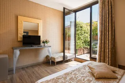a bedroom with a bed and a television and a window at Atlante Garden Hotel in Rome