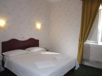 a bedroom with a white bed and a window at Hotel Texas in Rome