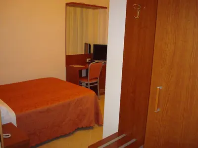 a bedroom with a bed and a desk with a computer at Hotel Priscilla in Rome