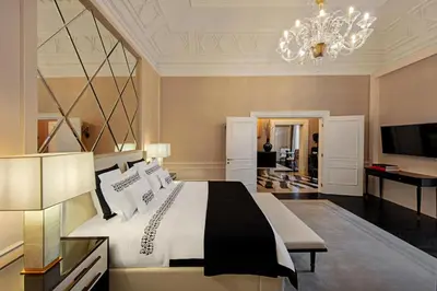 a bedroom with a large bed and a chandelier at The St. Regis Rome in Rome