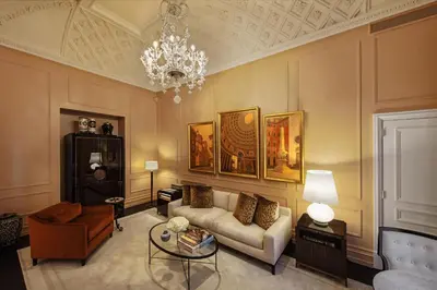 a living room with a couch and a chandelier at The St. Regis Rome in Rome