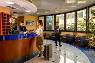 a woman standing at a bar with a suitcase at Best Western Blu Hotel Roma in Rome