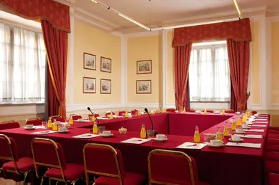 a large meeting room with red tables and chairs at Bettoja Hotel Atlantico in Rome